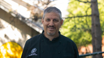 photo of a chef smiling in a black coat