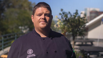 photo of a chef in a black coat smiling