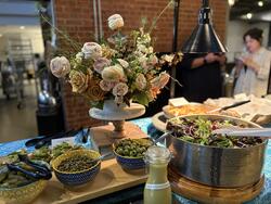 Spread of olives, salad, and dressing with a large bouquet of flowers