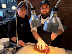 two chefs carving a large steak in The Met