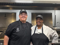 two dining staff members smiling at the camera